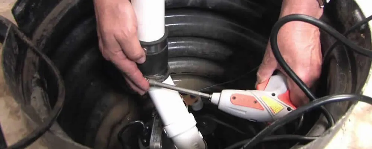 Sump pump installation technician connecting PVC discharge piping in Boulder, CO